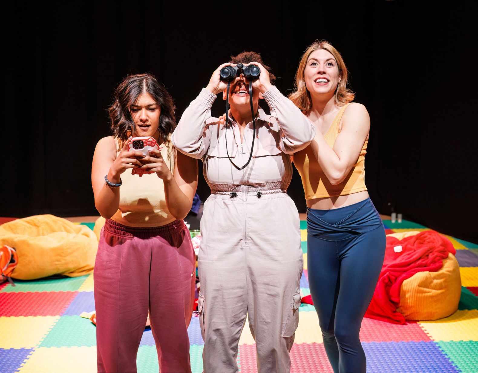Production photo of Rotten by Emmerson & Ward - three young women are looking through binoculars at something shocking