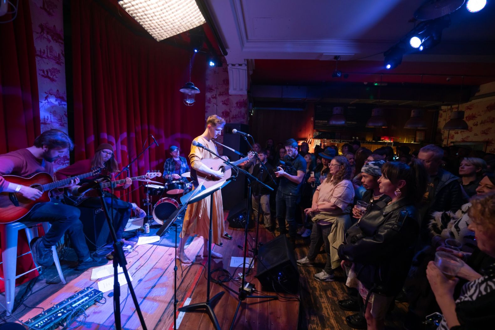 Bay Bryan performing with guitar in front of an audience