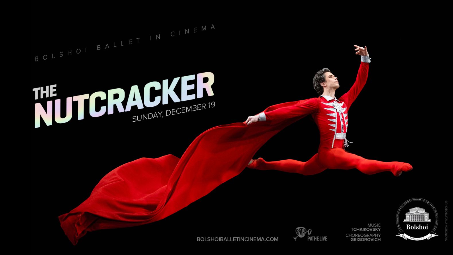 Bolshoi Ballet Promo Image: A ballet dancer in a red leotard, red tights and red billowing cape leaping.