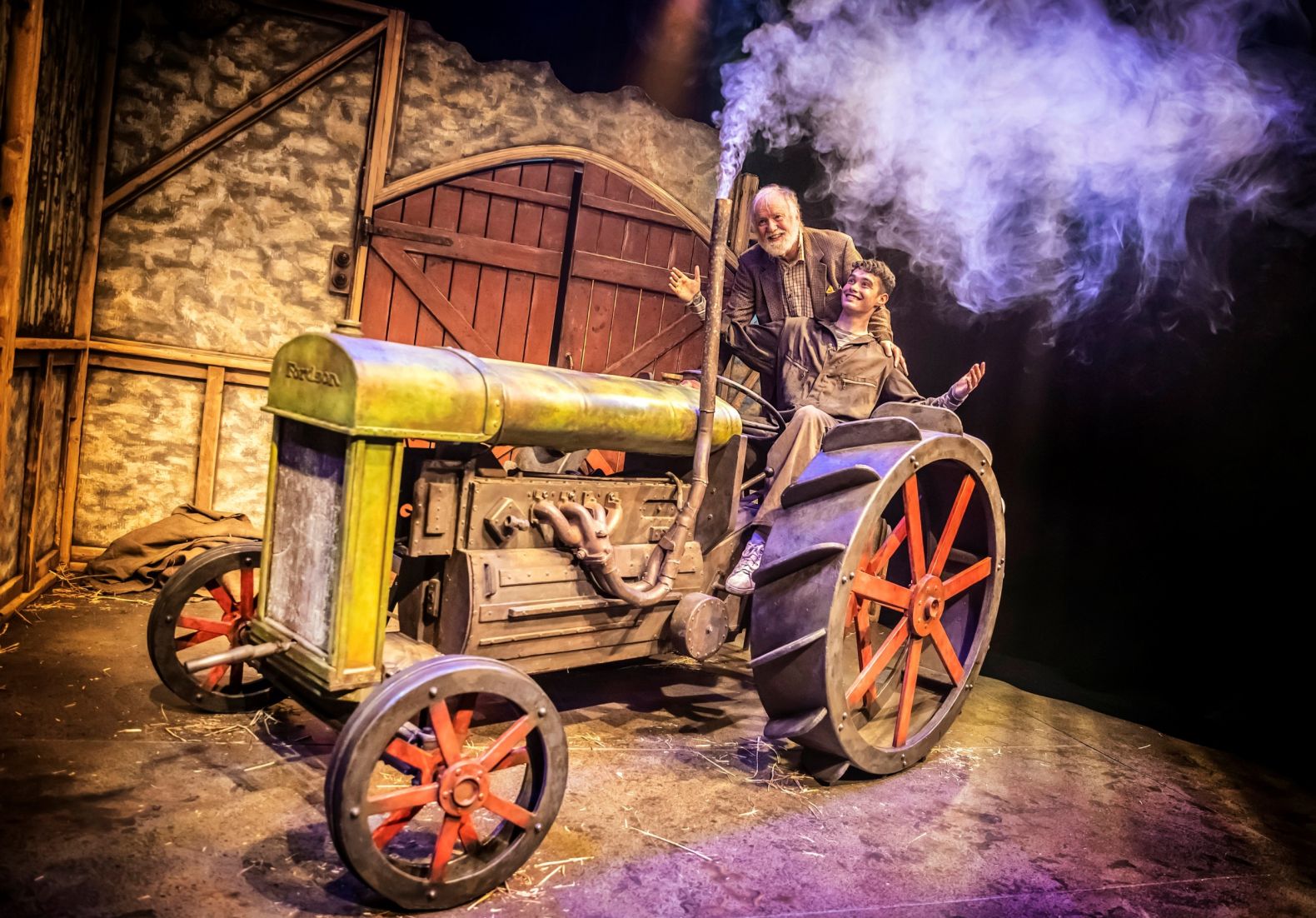 a young man and an old man in a tractor