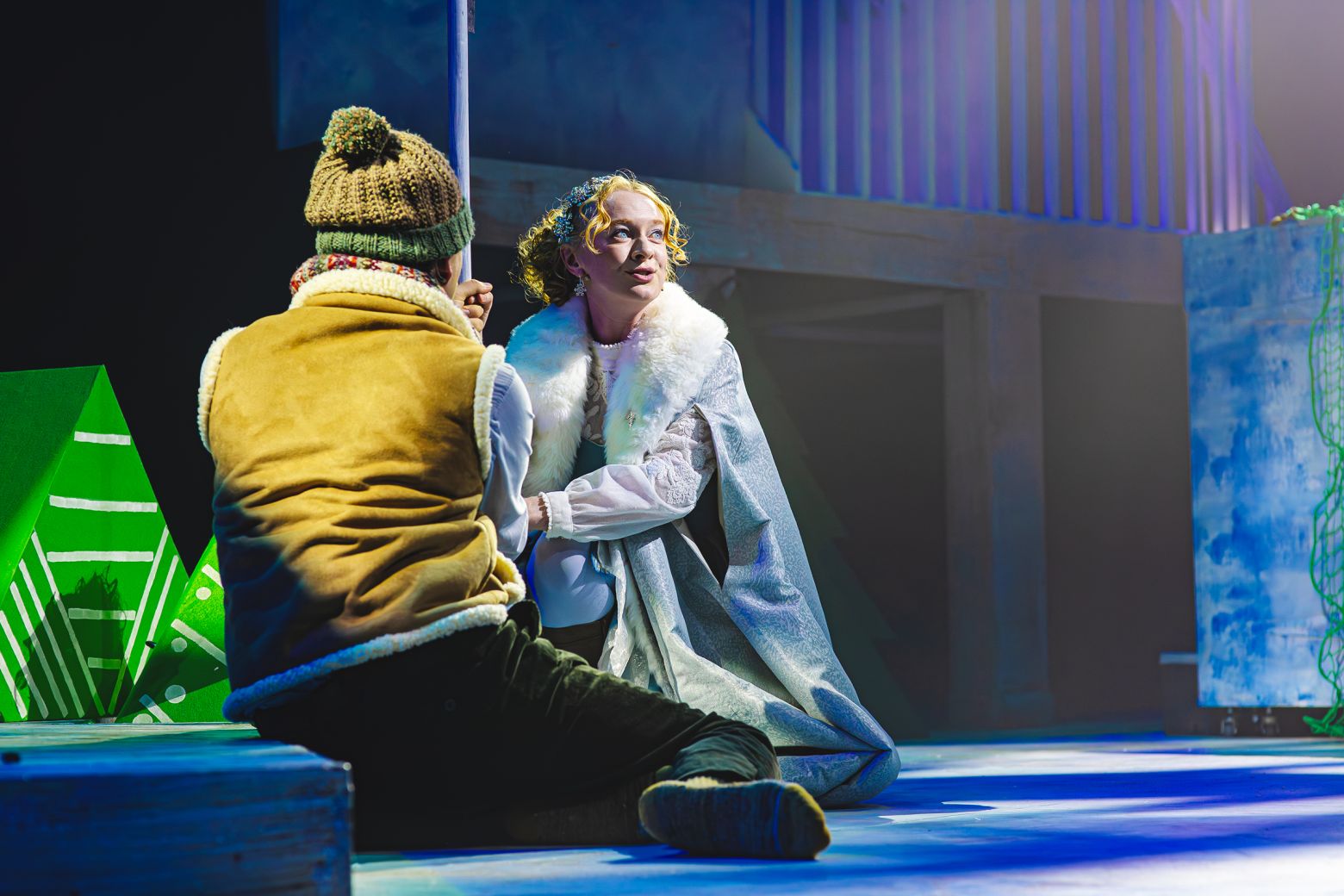 The Snow Queen at the Dukes - The Snow Queen sits on the floor singign to Kia who has his back to camera.