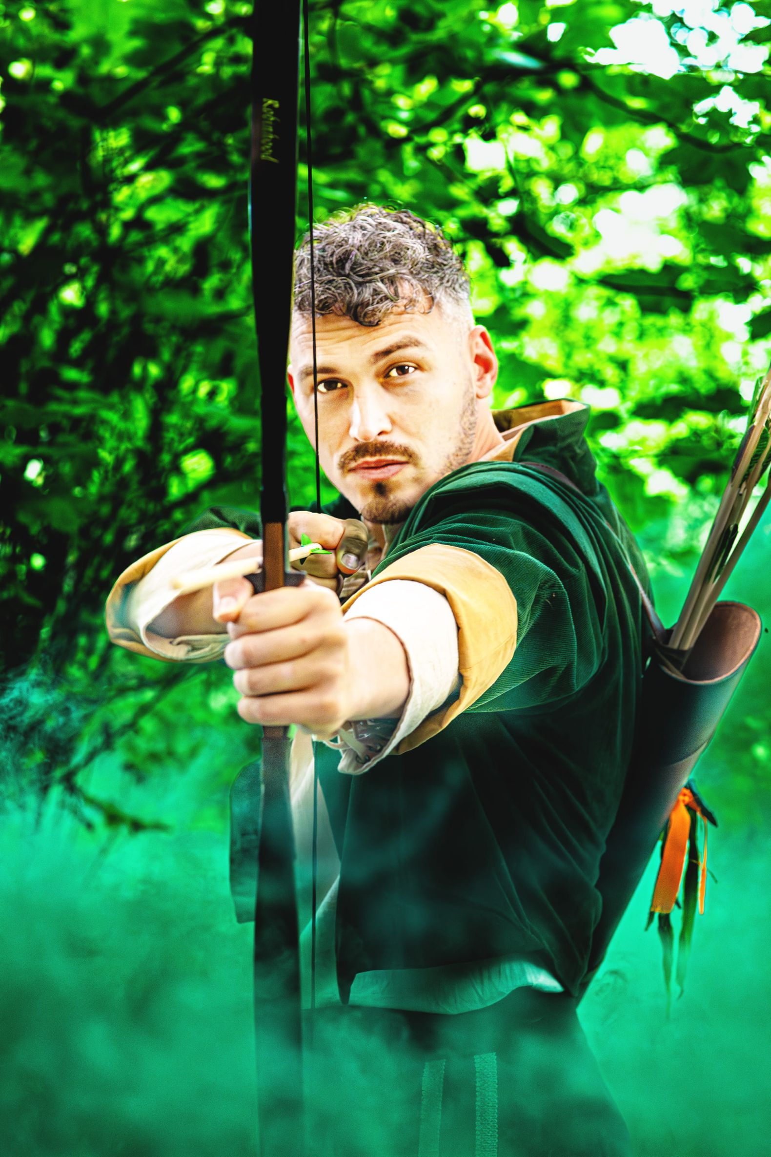Robin Hood - the Dukes Park Show in Williamson Park: Robin Hood stands holding his bow and arrow surrounded by green smoke