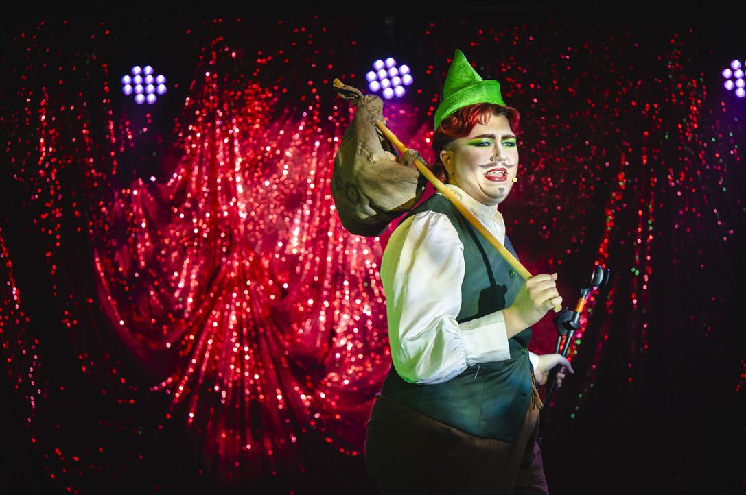 a performer dressed as Robin Hood with heavy make-up and false beard and moustache