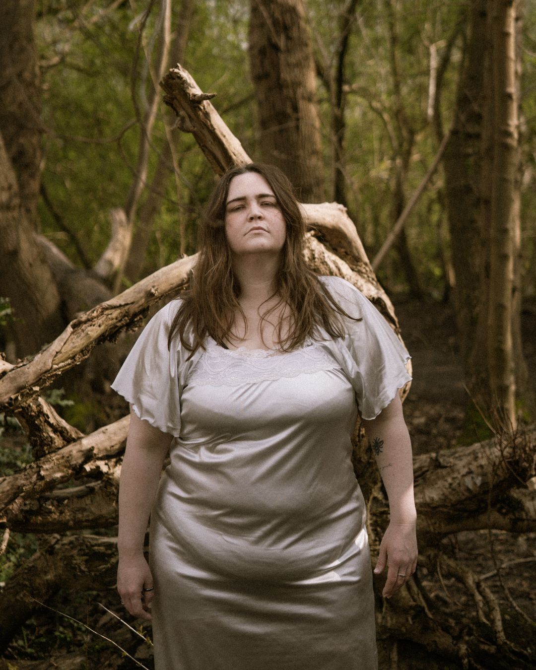 performer in white silk dress leaning against fallen tree - Macbeth by HER Productions at The Dukes, Lancaster