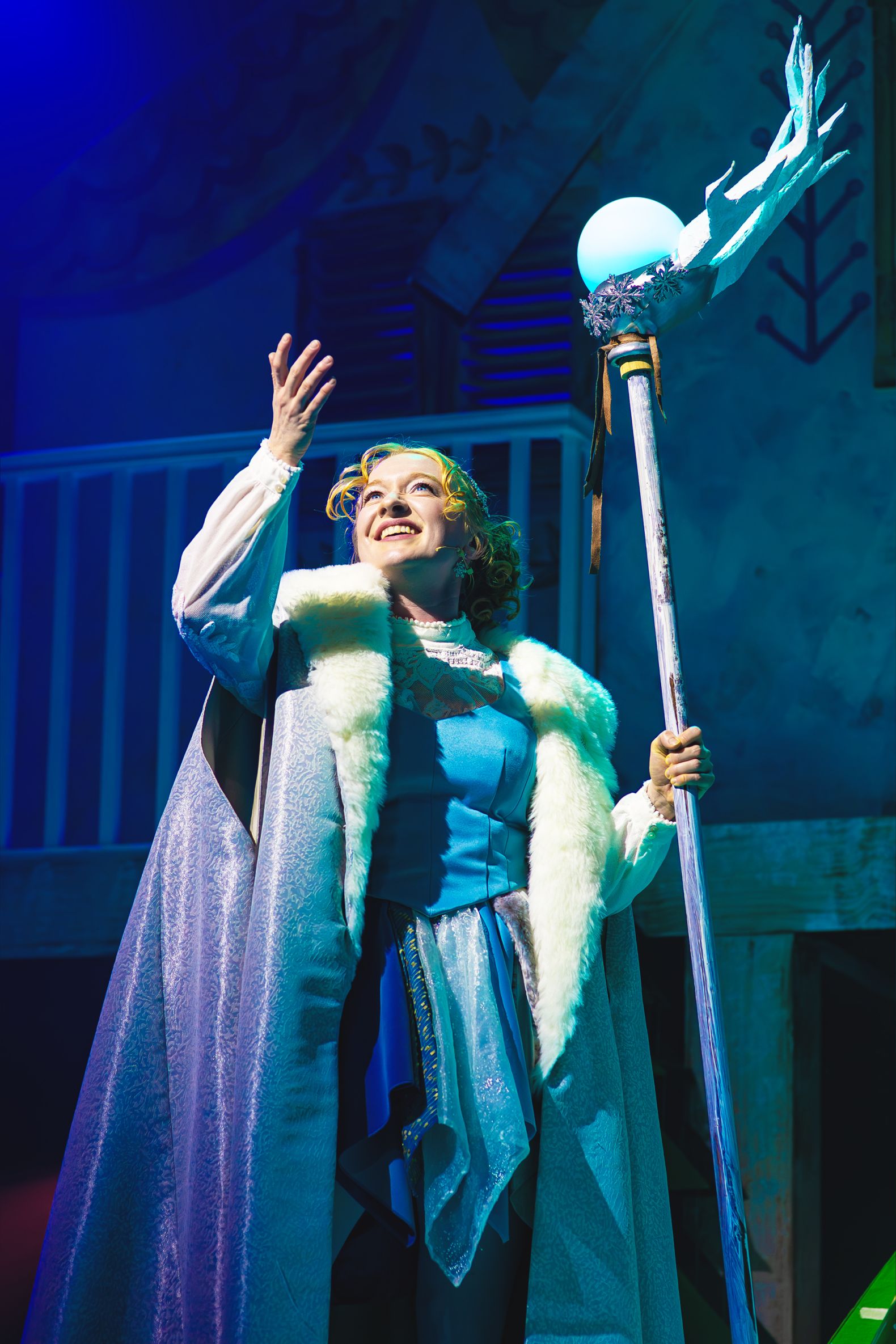 The Snow Queen at The Dukes - Tori Burgess (The Snow Queen) wears an icy blue cape and holds a staff made of ice topped with an antler.