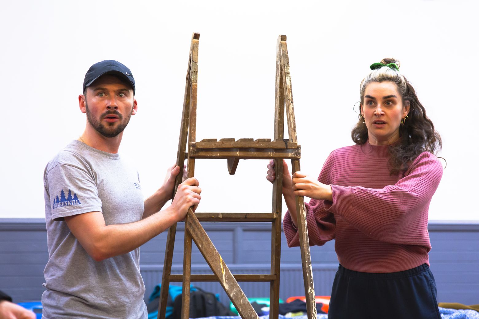 Miriam O'Brien and Cameron McKendrick, actors in A Christmas Carol, holding a stepladder in the rehearsal room
