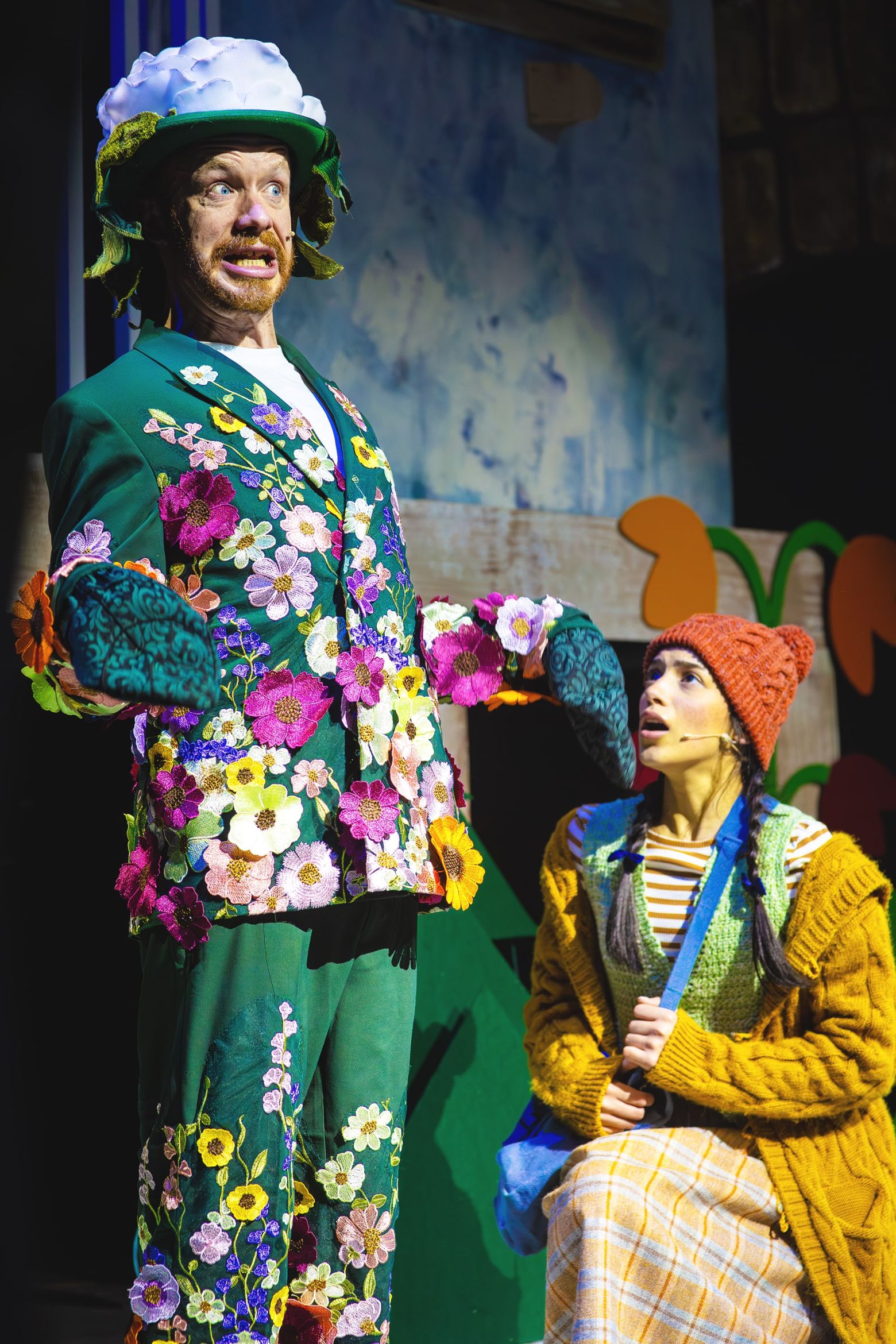 The snow Queen at The Dukes - Ninny Rose and Gerda, Ninny Rose wears an emerald green suit covered in flowers.