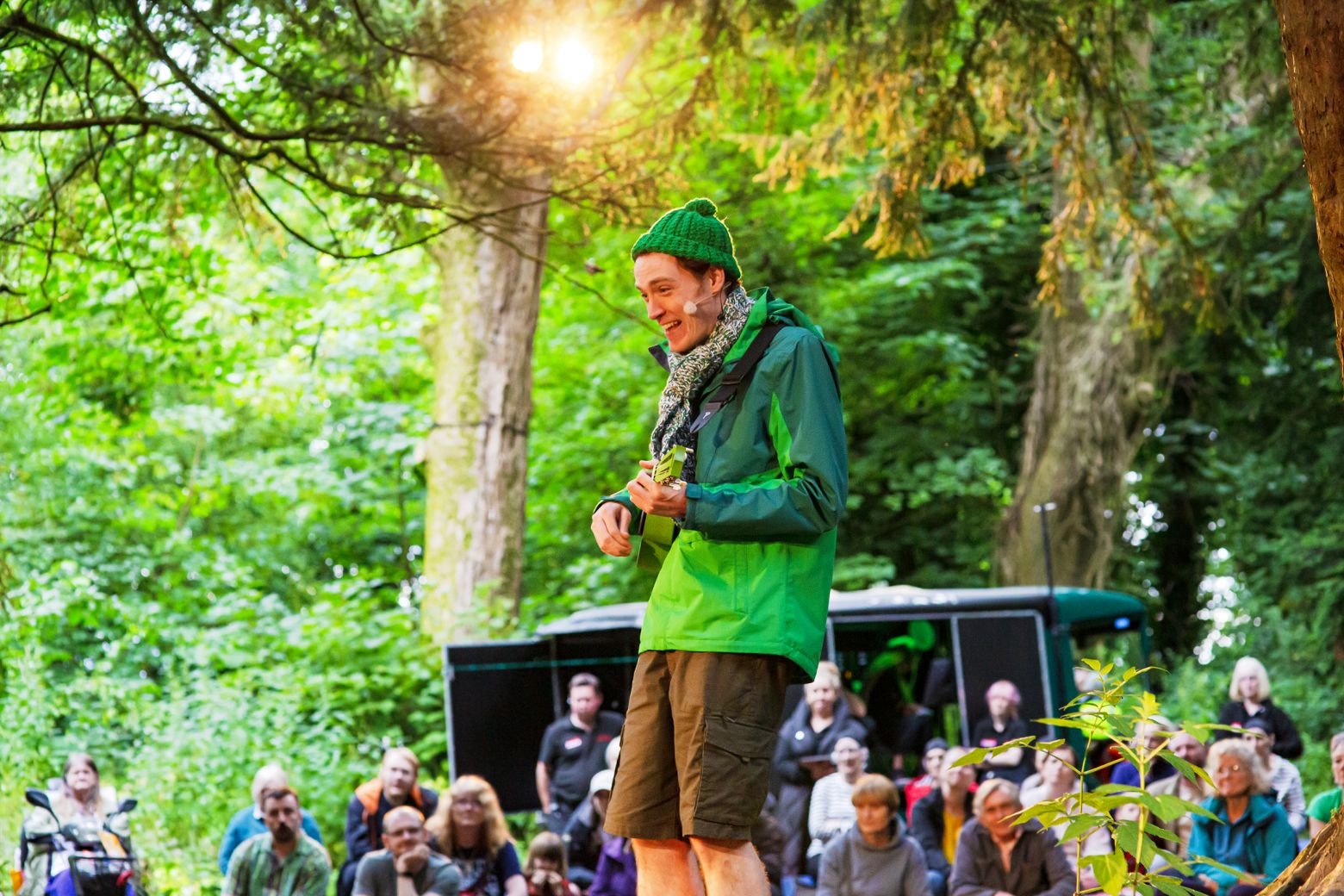 Alice in Wonderland at the Dukes. The character, Lewis, plays a green ukulele in the woodlands for the opening scene in Williamson Park.