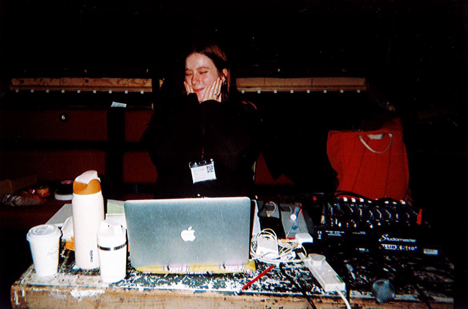 Ella Kirk - Deputy Stage Manager smiling to camera sat behind a tech desk