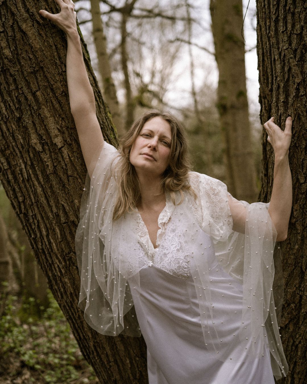 performer in white dress and shall leaning on a tree - Macbeth by HER Productions at The Dukes, Lancaster