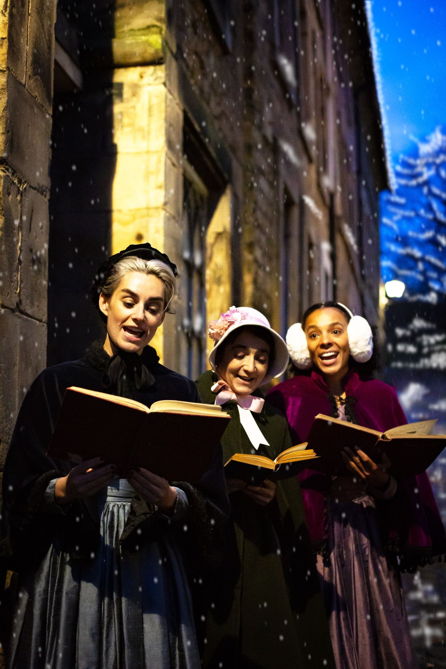 Three carol singers, singing outside in the snow