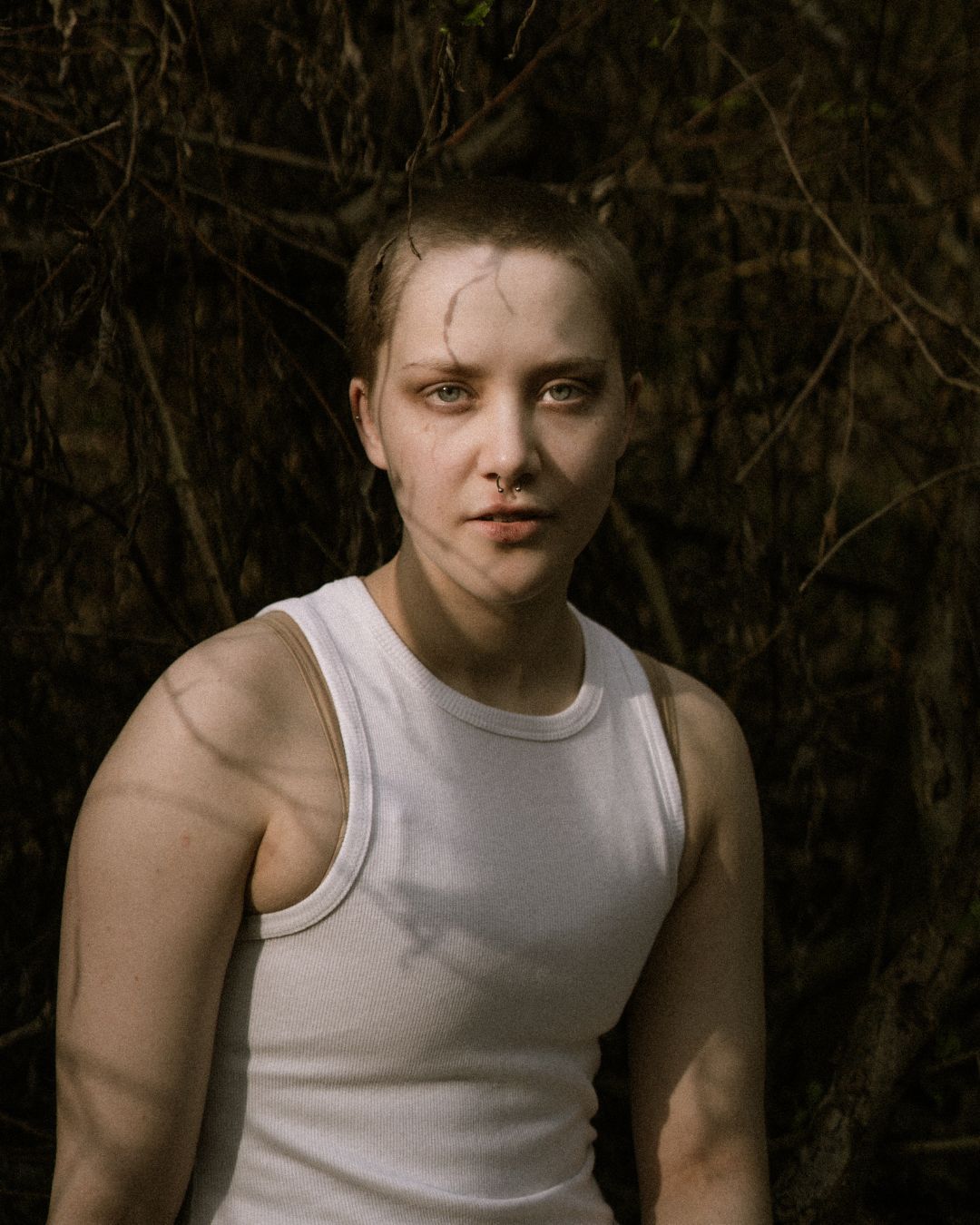 performer in white vest stood against a wall - Macbeth by HER Productions at The Dukes, Lancaster