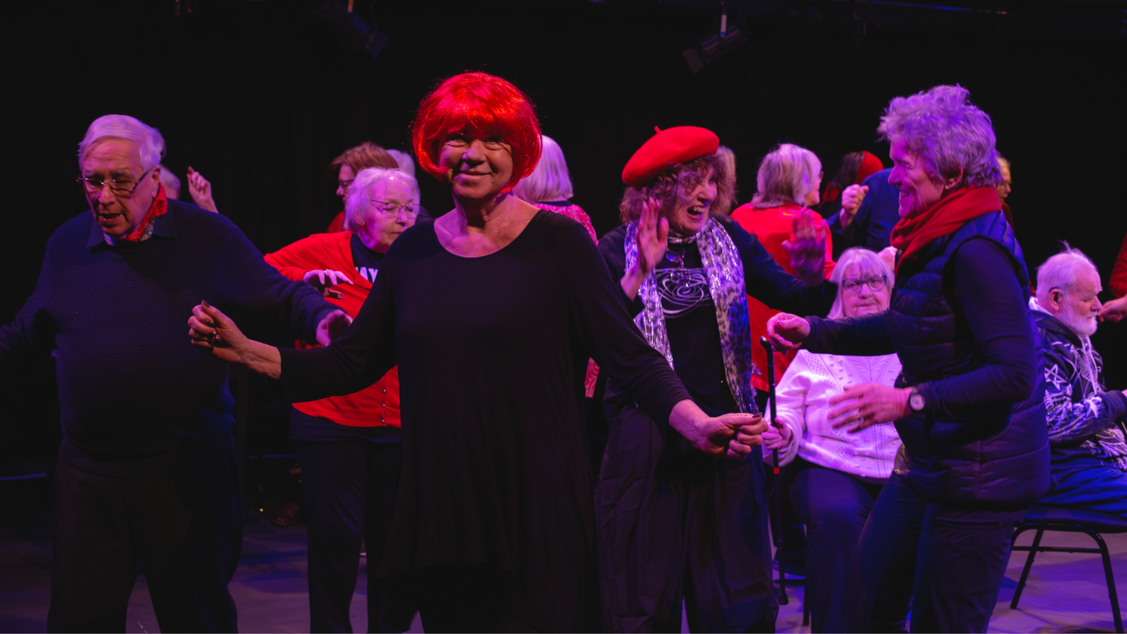 Prime Time Members wearing red and black, dancing on stage