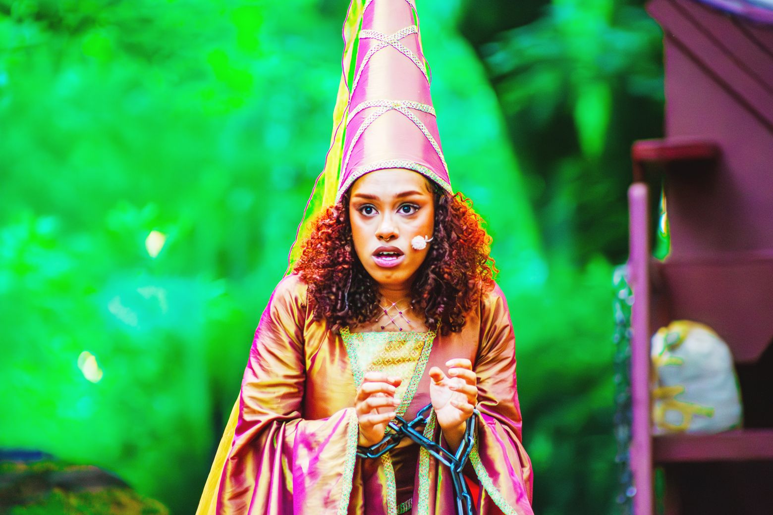 Hope Yolanda as Marian, hands bound in chains, looks on at the scene before her. 