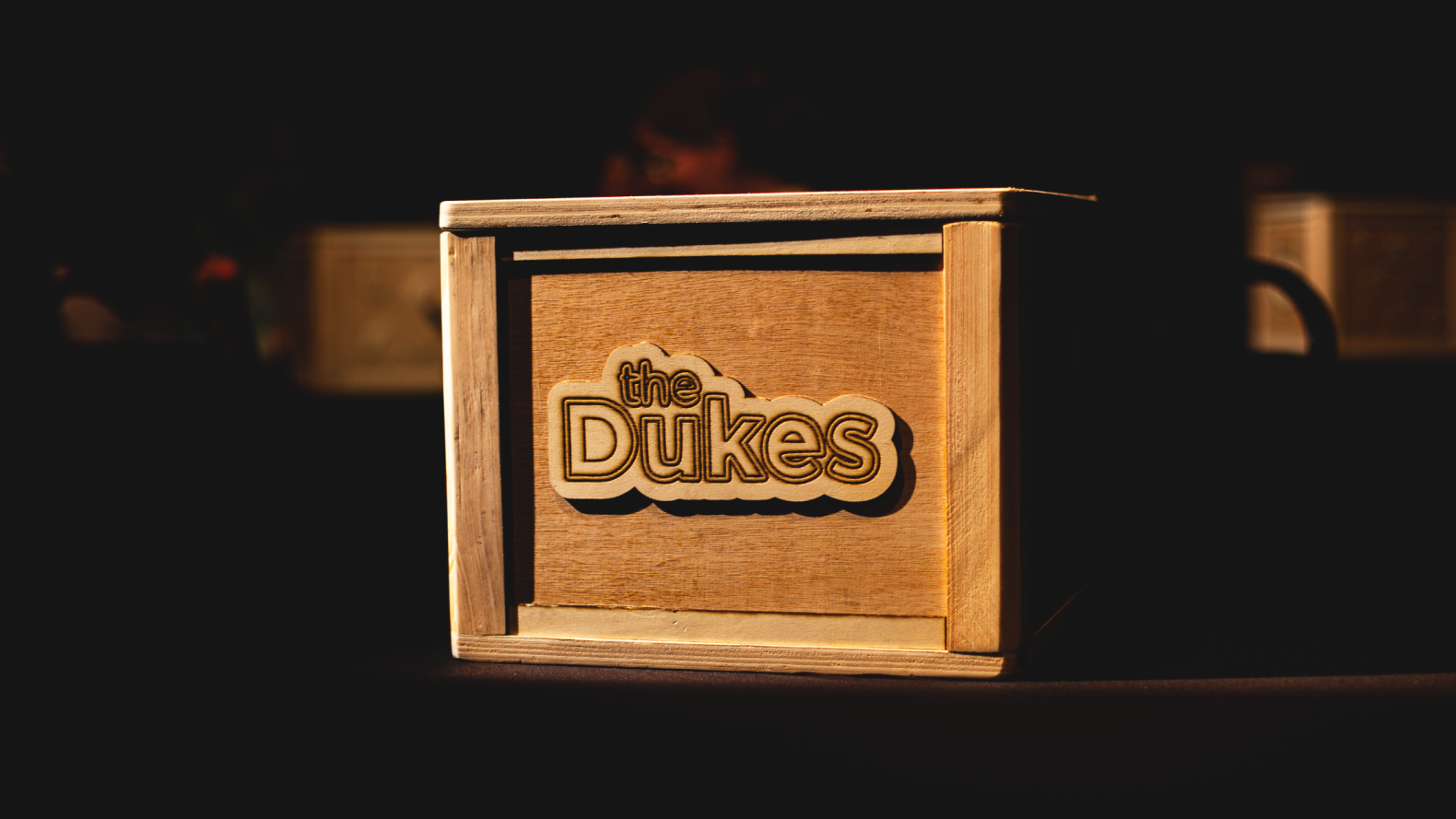 The front of a wooden box with a Dukes wooden label.