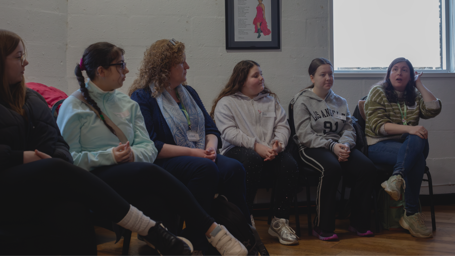 Young Carers and their leaders sitting on chairs along the wall. 
