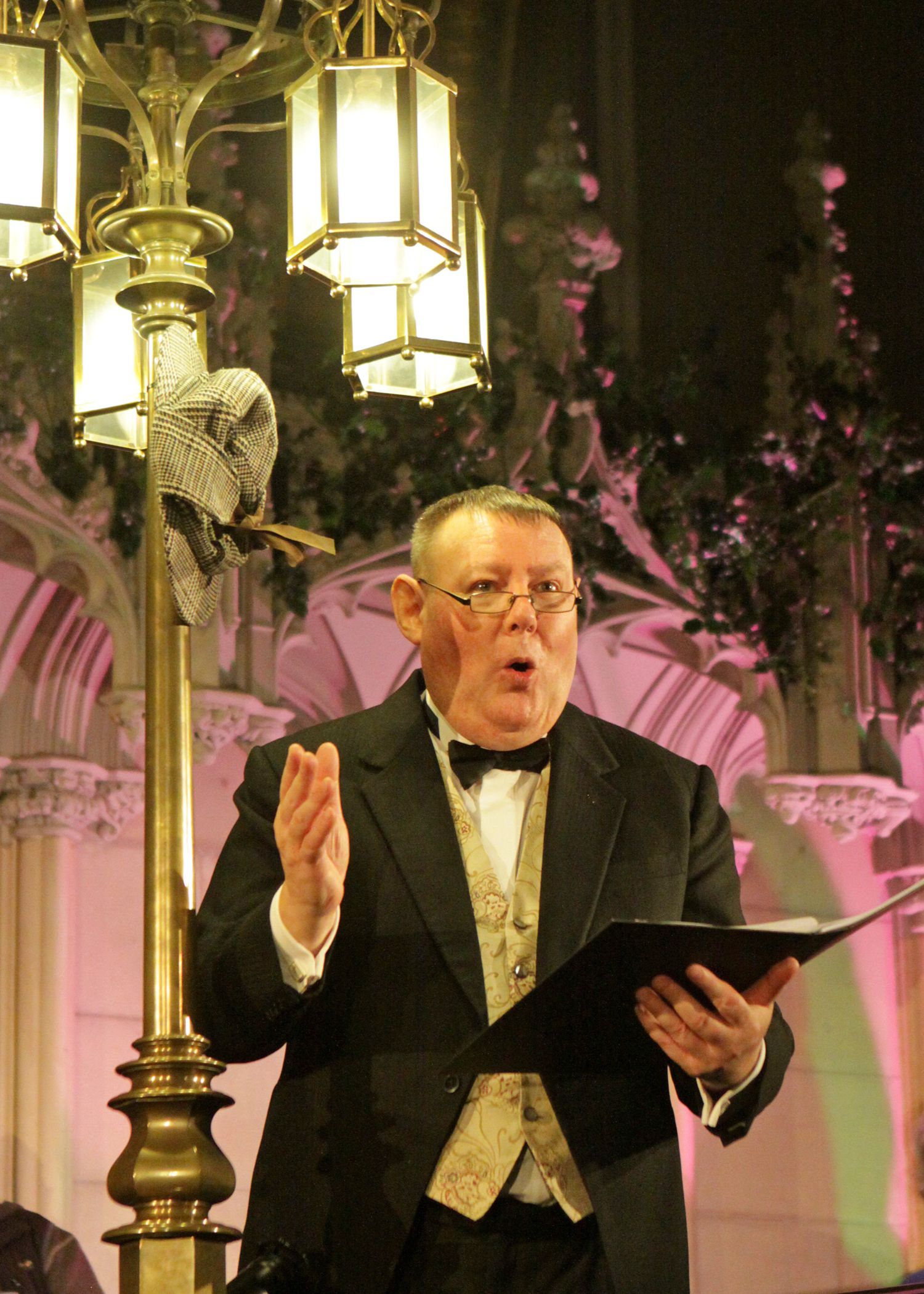 Peter Rylands wears a Suit in a church while singing