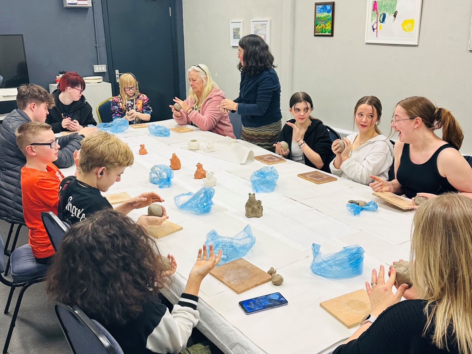 young carers sat around a large table at a Clay Workshop