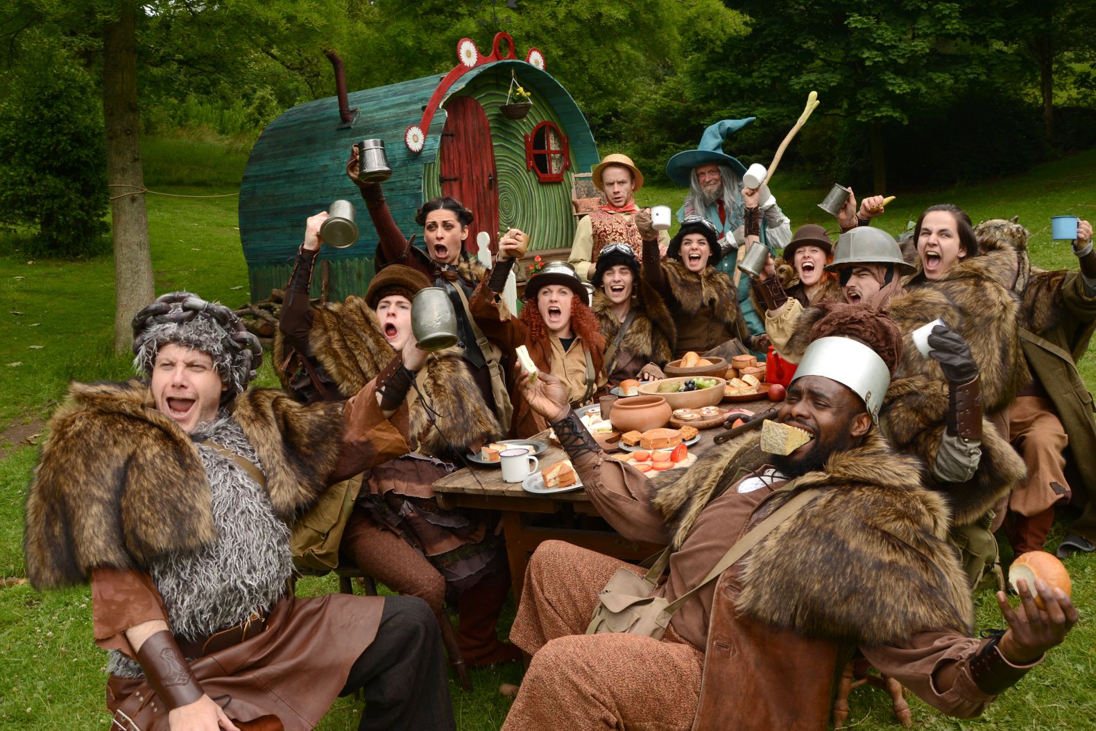 Actors dressed as hobbits raise there drinks in glee