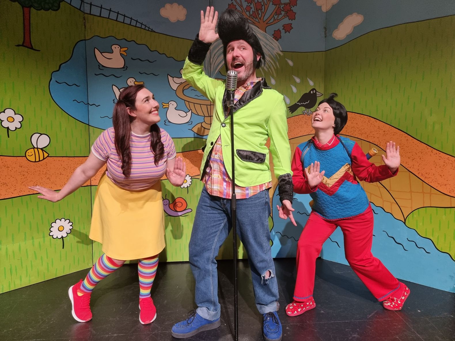 three cast members in mid-song - the central character has a large quiff