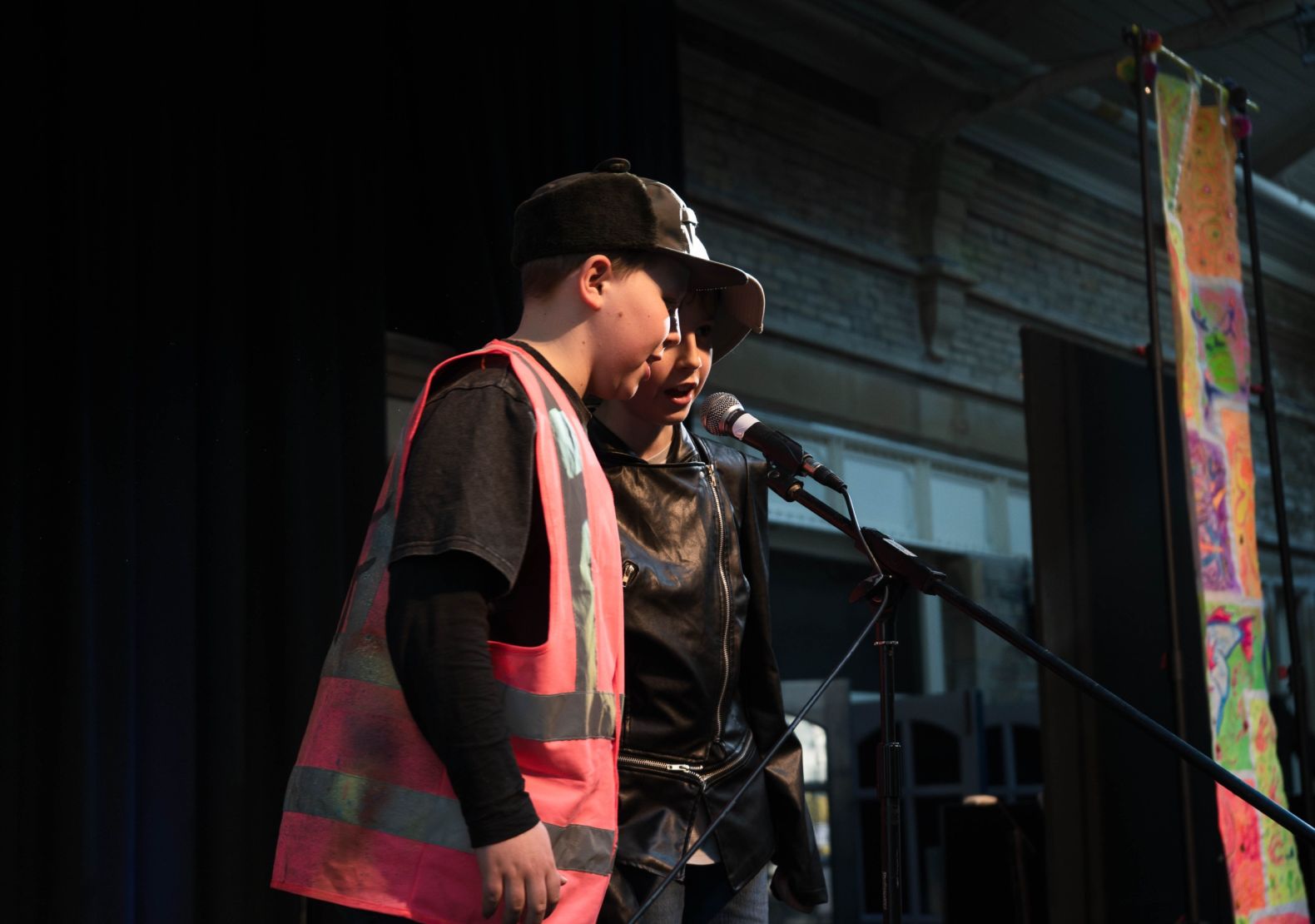2 young boys at a microphone singing