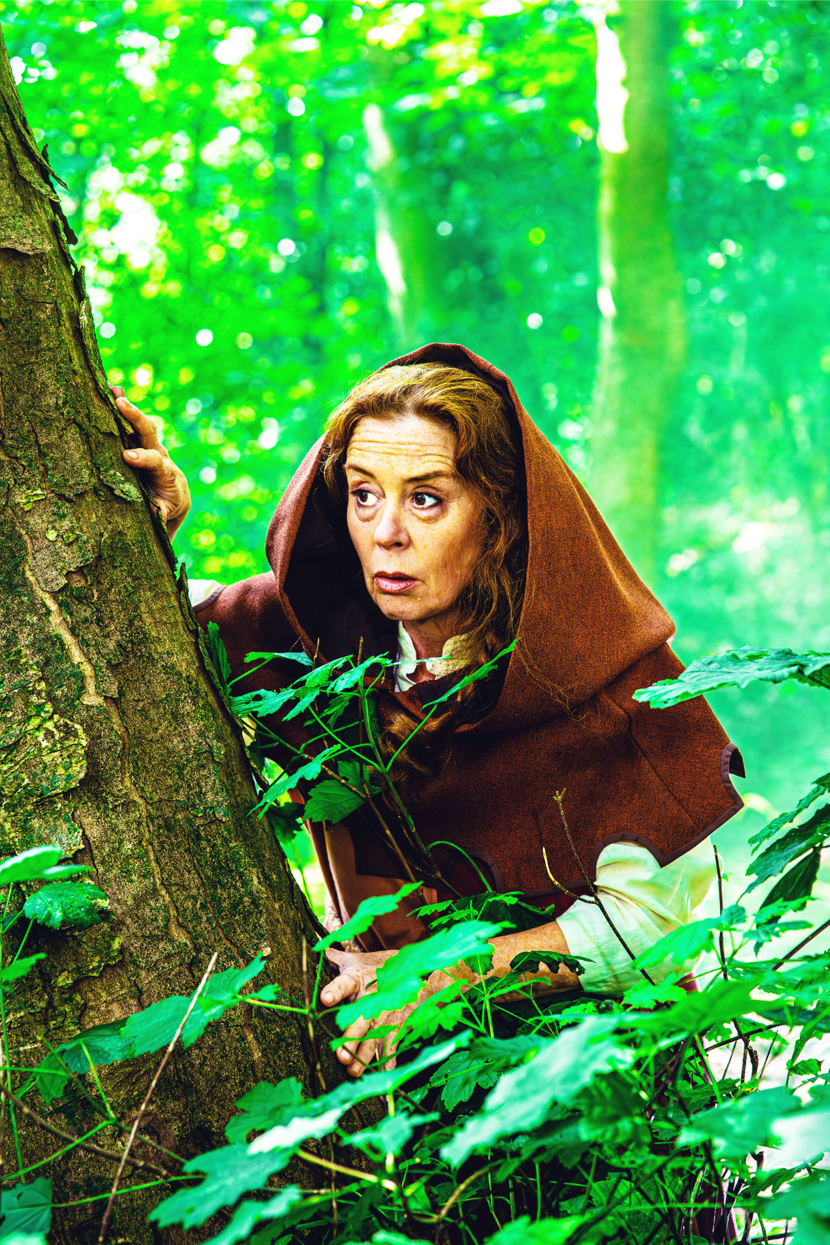 Friar Tuck in the park peaking from behind a tree