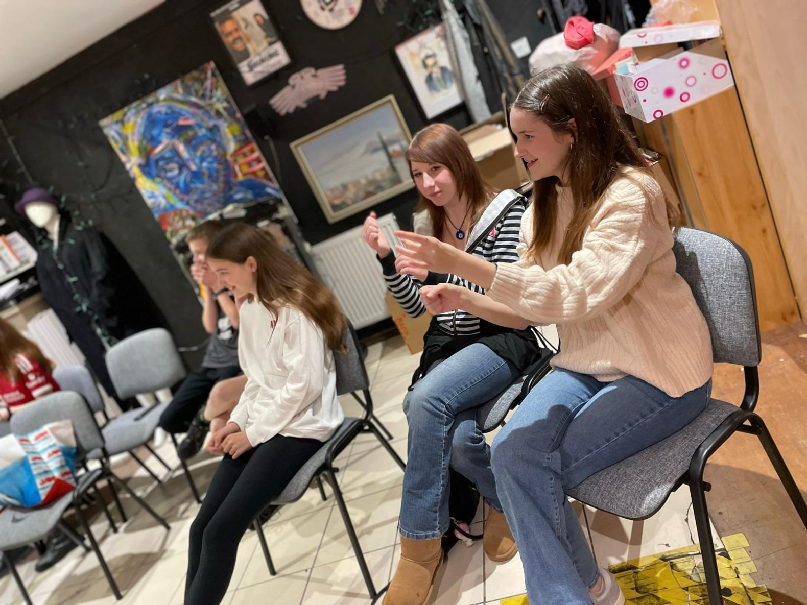 young people sat on chair watching something off camera