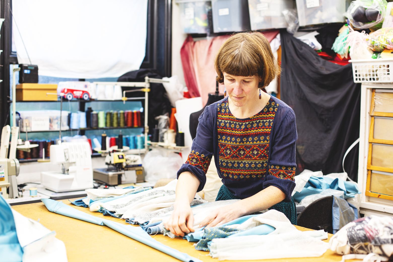 Wardrobe assitant Roisin working on a light blue and white trimming.