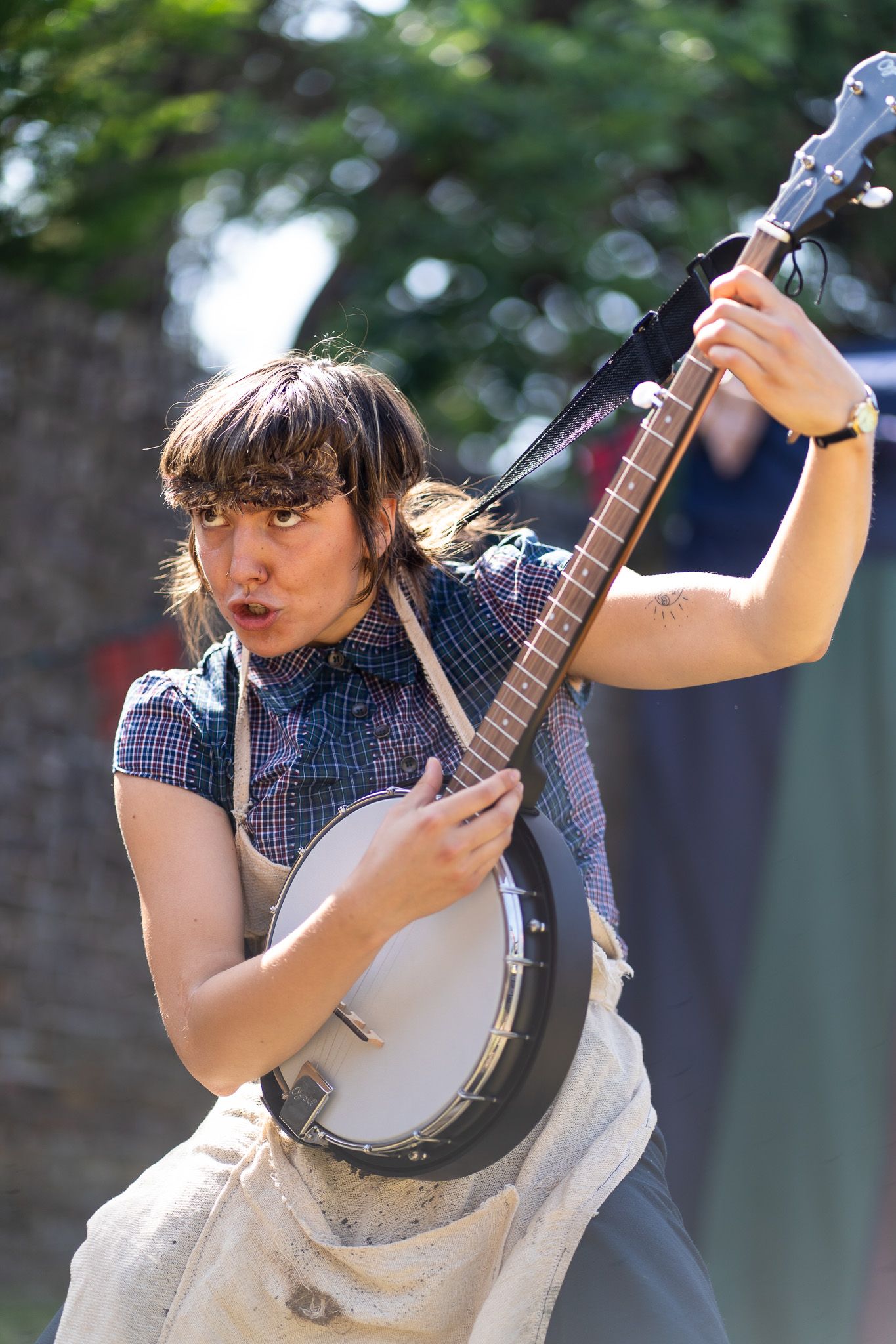 A cast member intensely plays a banjo.