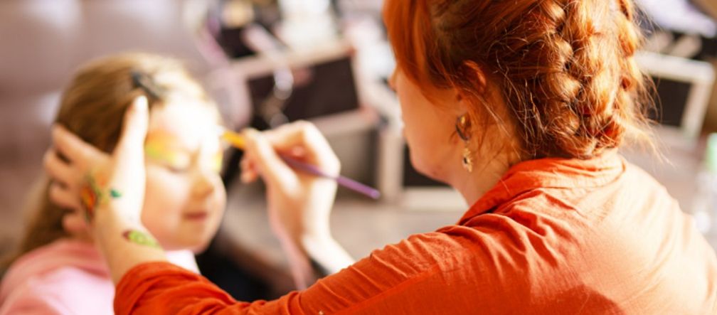 face paint being applied to a young childs face