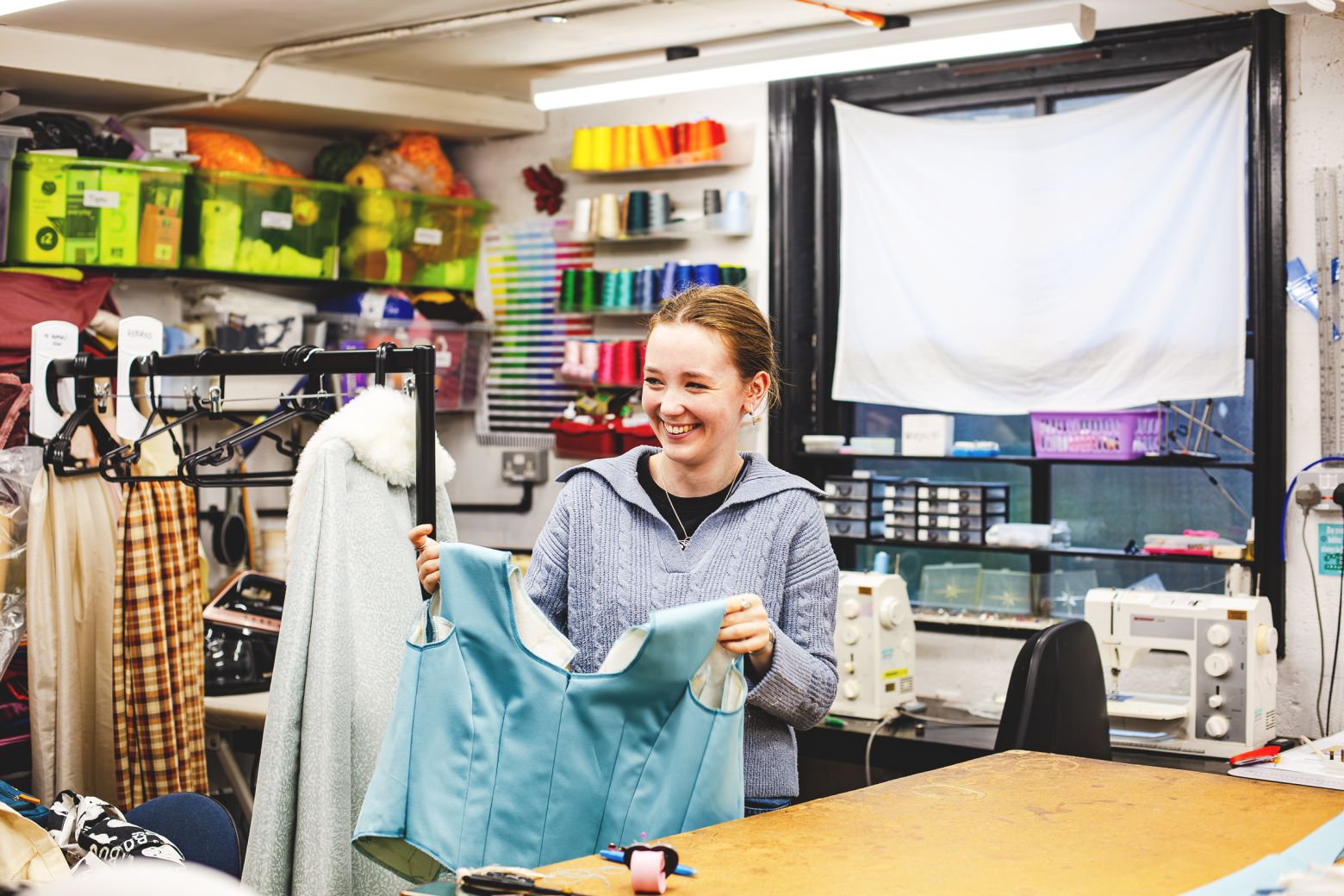 Wardobe assistant holding a light blue corset