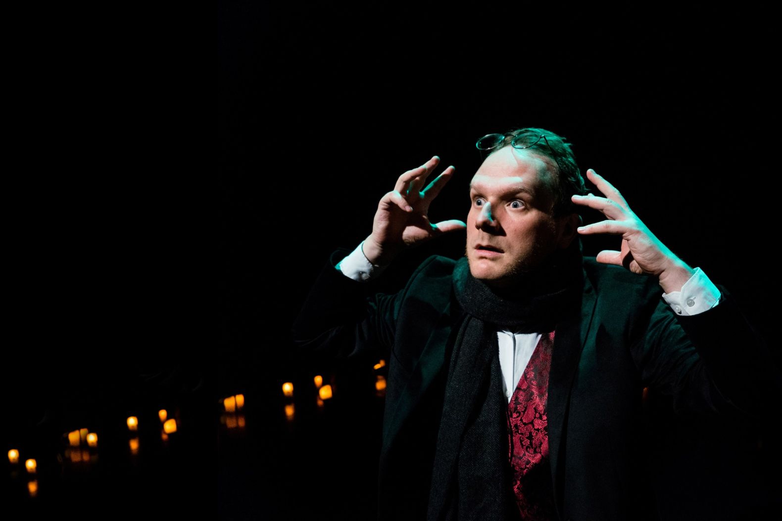 Actor dressed in Victorian attire, his hands raised to his head as if in shock