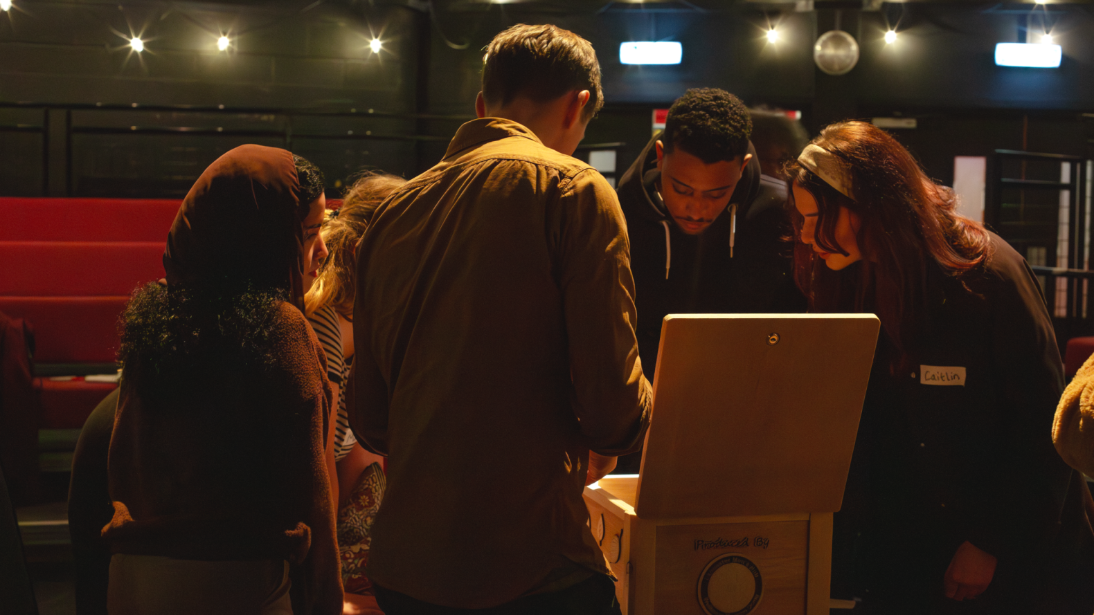 RAIS and Adam standing around a table with a wooden box. 