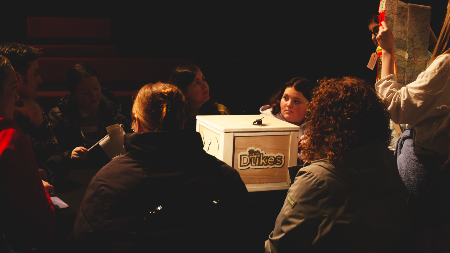 Young Carers, their leaders and More Music members sitting around a table with wooden box in the middle.