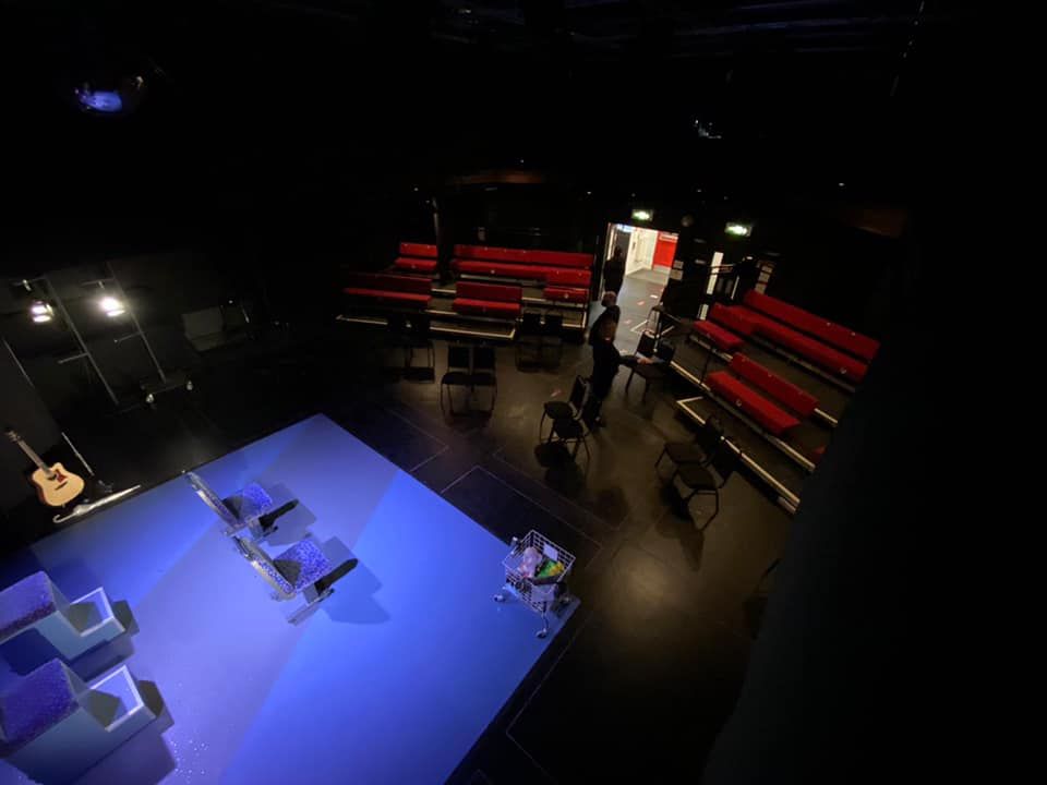 100 seater auditorium with red benches facing the stage