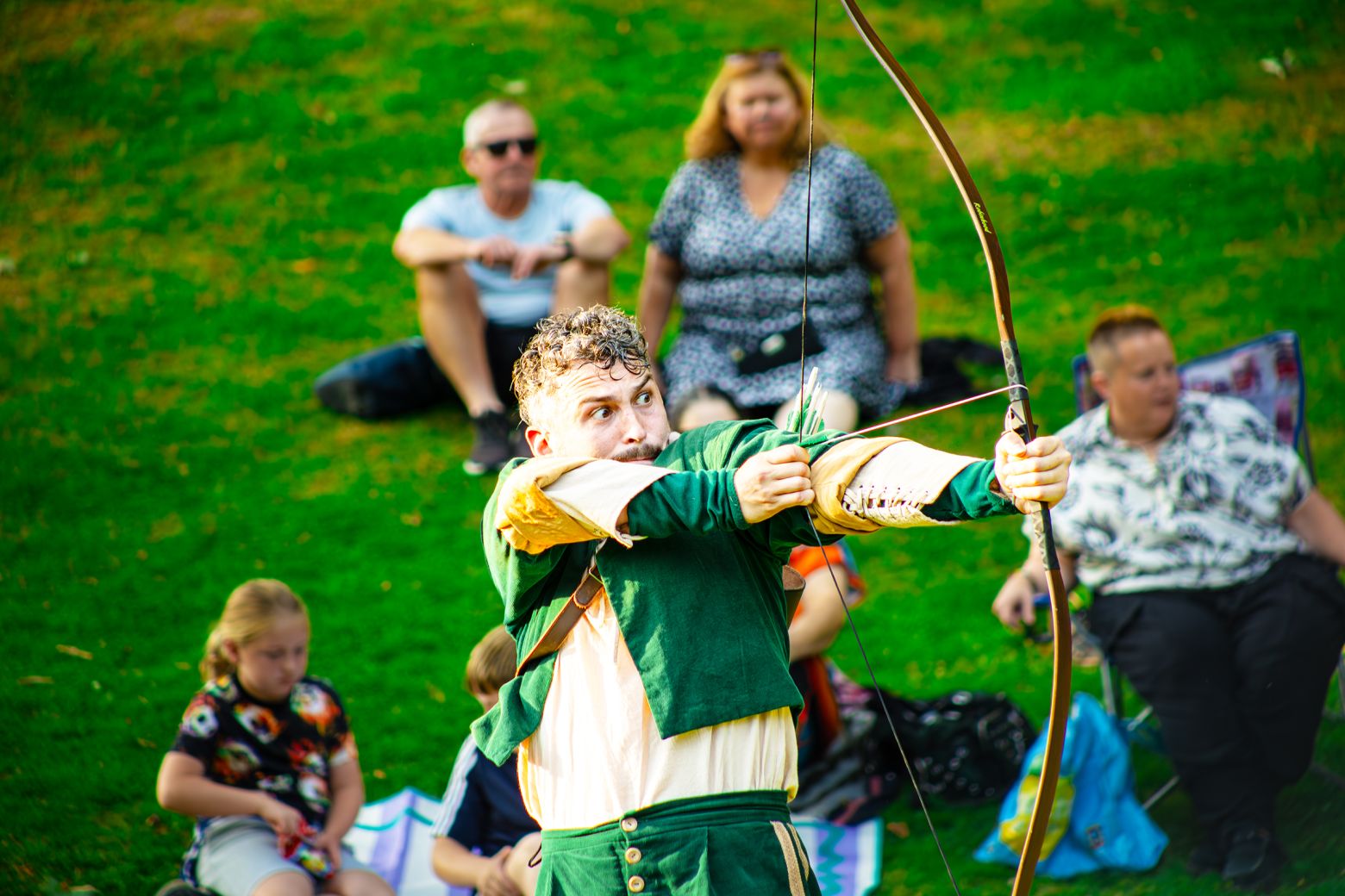 Joe Parker as Rob aims a bow and arrow.